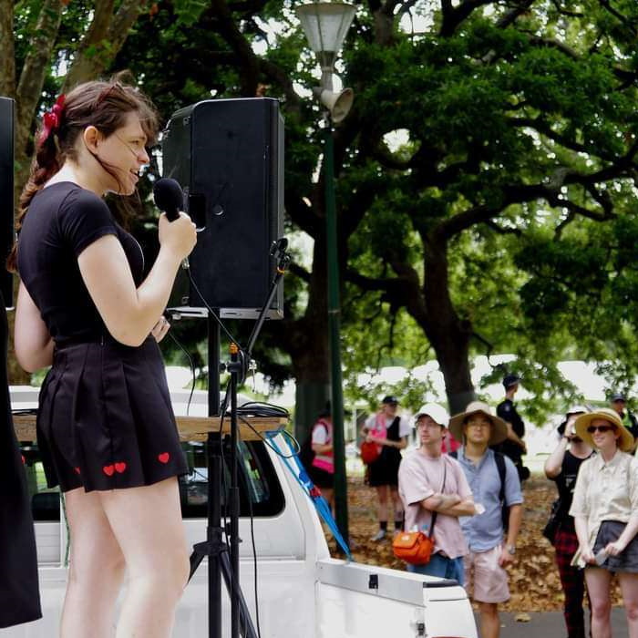 Natalie outside, speaking at a protest.